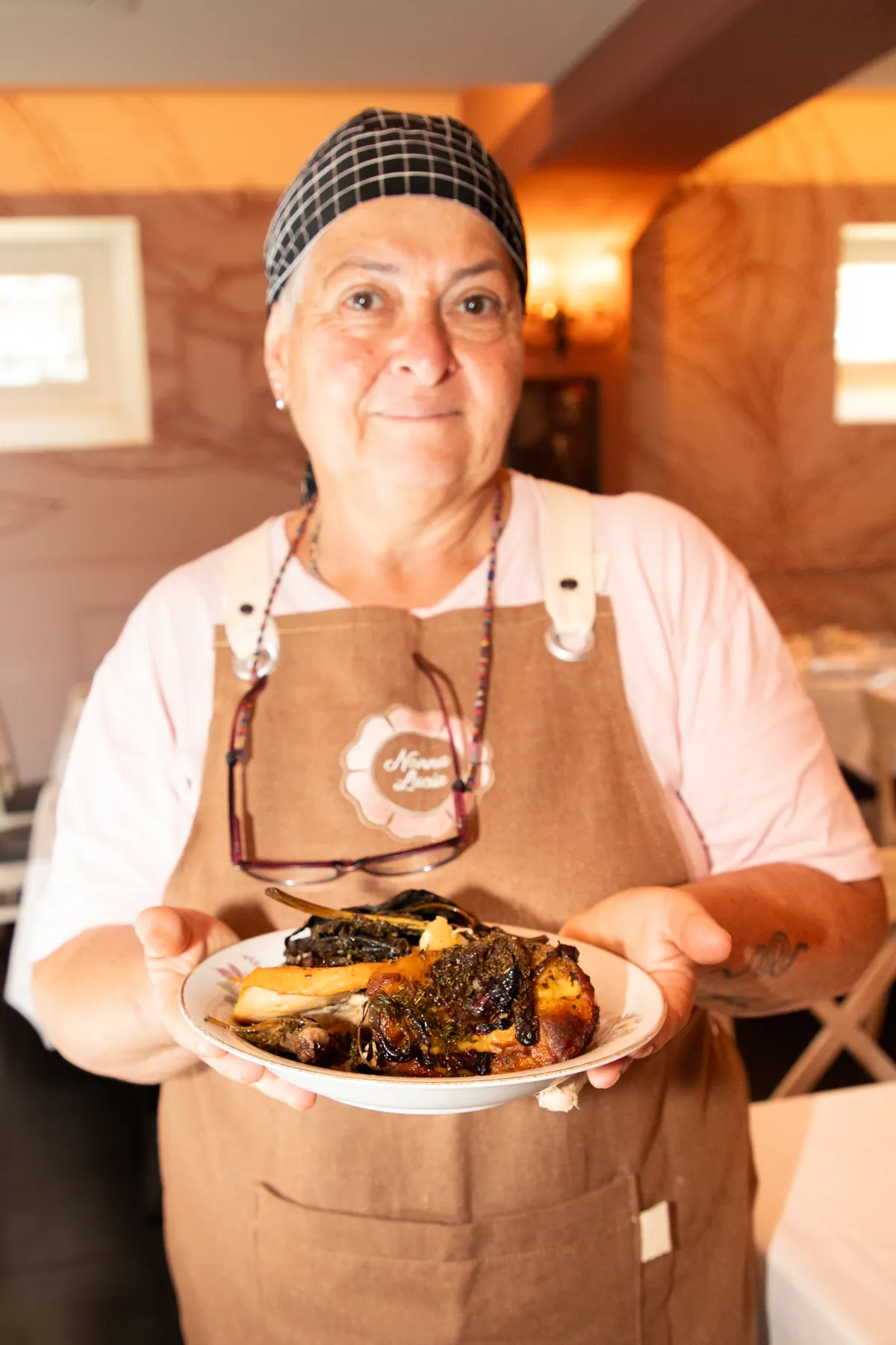 Lucia in cucina con un piatto preparato nella trattoria